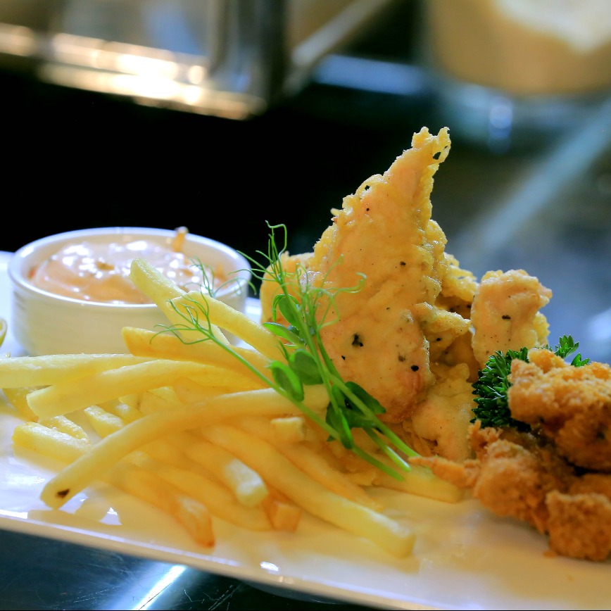 Close-up of crispy chickens served with potato fries